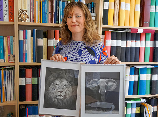 Daniela Argento med tavlor p&aring; ett lejon och en elefant.