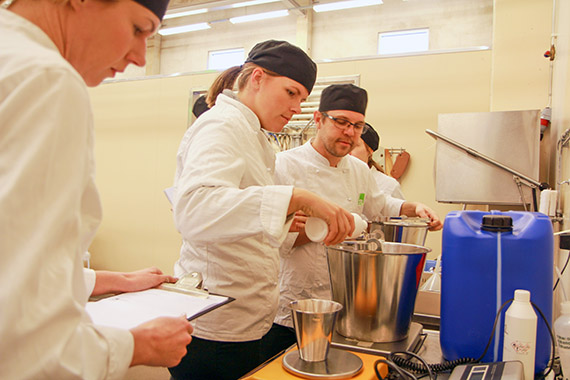 Gastronomistudenterna Filippa, Maja och Marcus m&aring;ttar upp 2 166 gram rabarberessens och 270 gram hibiskus.