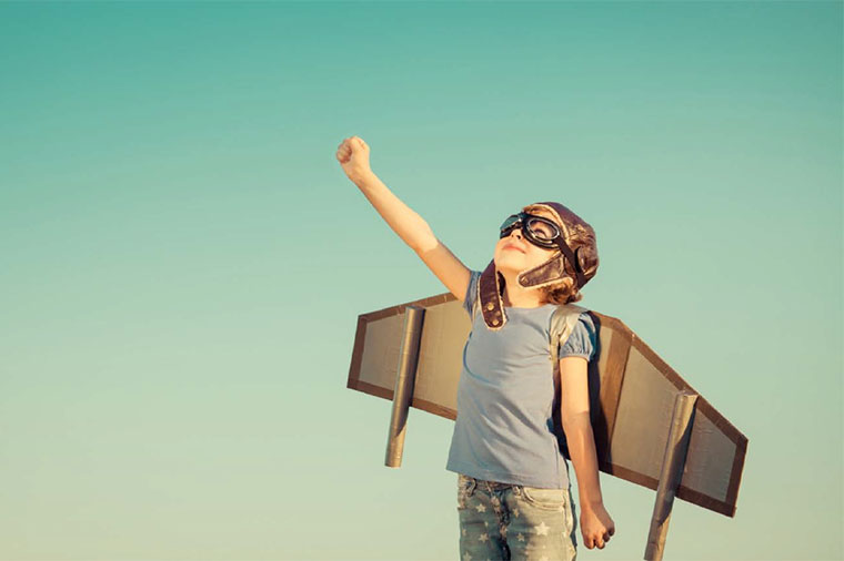 Pojke med leksaksraket på ryggen.