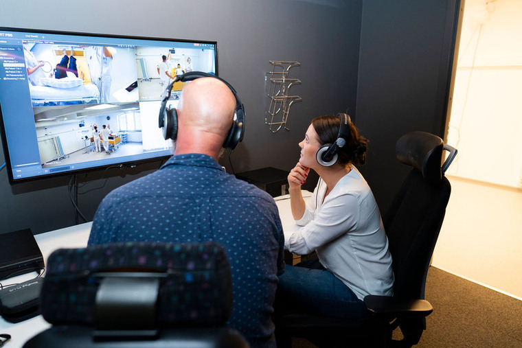 Tv&aring; l&auml;rare tittar p&aring; simulerings&ouml;vning p&aring; en tv-sk&auml;rm.