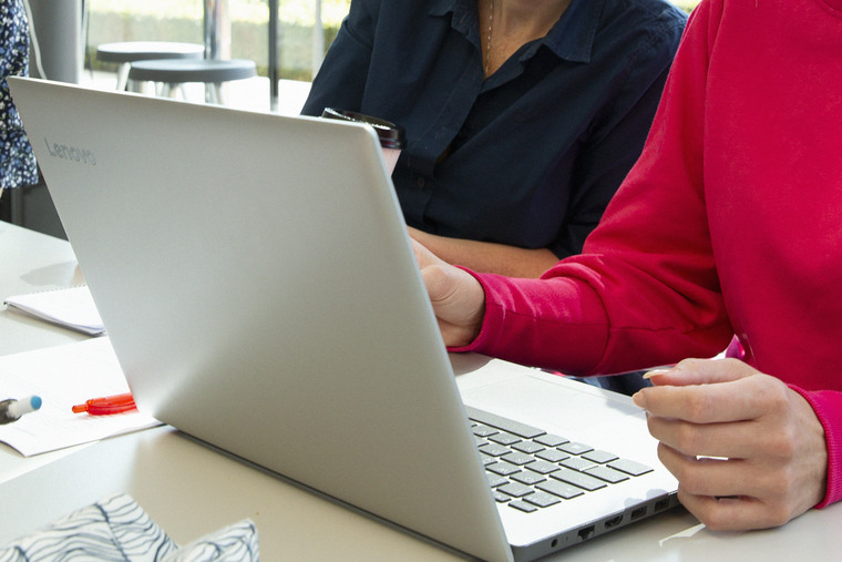 Tre tjejer sitter med dator i glashuset.