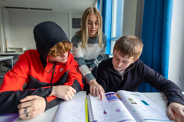 H&ouml;gstadiel&auml;rare visar tv&aring; elever i ett klassrum.