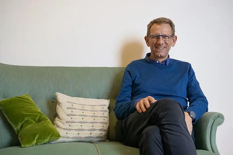 G&auml;stprofessor Simon Down sitter i en soffa.