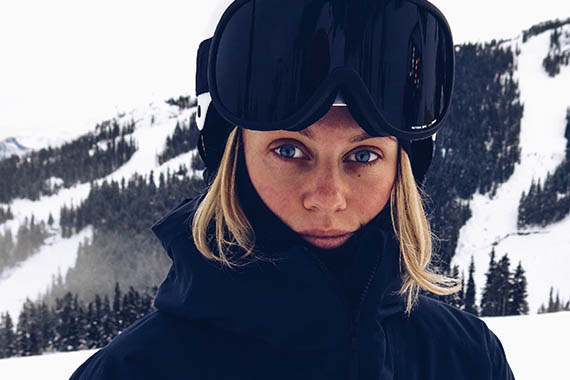 Distansstudenten Johanna med skidutrustning, snötäckta berg i bakgrunden