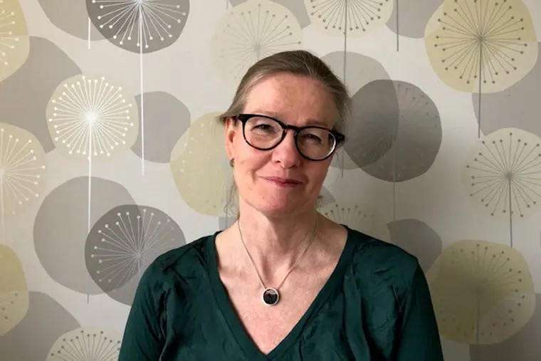 Lektor Malin Sundström framför en mönstrad tapet