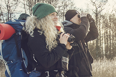 Studenter med kikare ute i naturen.