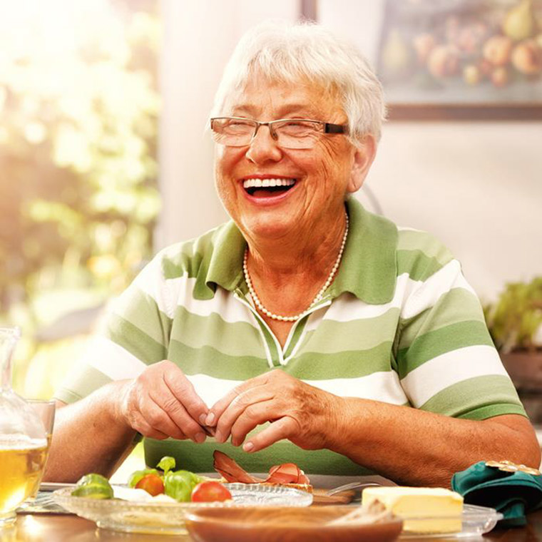 Äldre person äter fingermat med fingrarna.