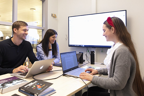 Studenter pluggar vid bord.