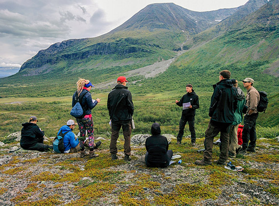 Magnus Redegard f&ouml;rel&auml;ser om hur jaktfalken g&ouml;r n&auml;r den jagar ripor i omr&aring;det. I bakgrunden reser sig det &ouml;ver tv&aring;tusen meter h&ouml;ga Akkamassivet. Foto: Johanna Gr&ouml;nroos