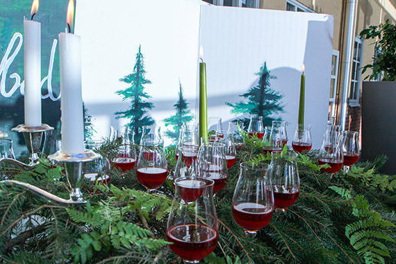 Glas med dryck placerade i granris. 