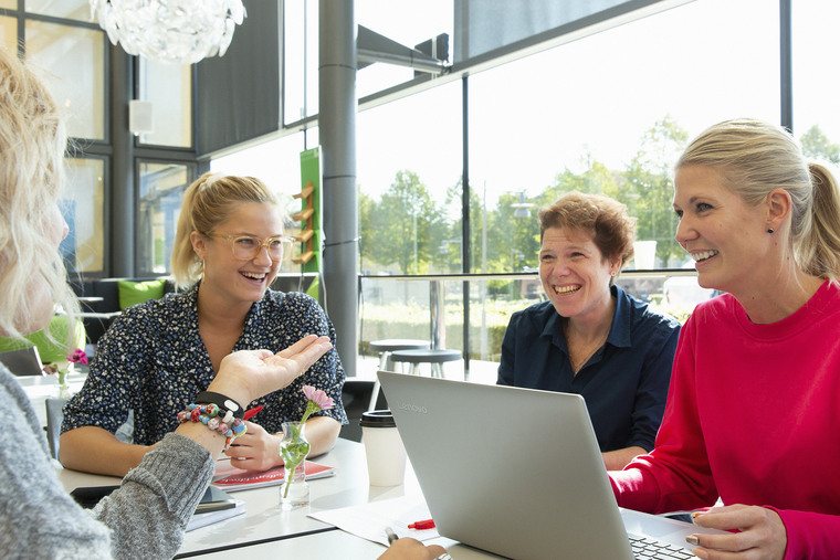 Tre tjejer sitter med dator i glashuset.