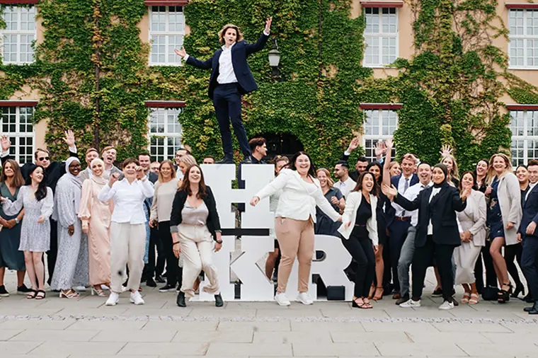 Studenter tillsammans med HKR-bokst&auml;verna.