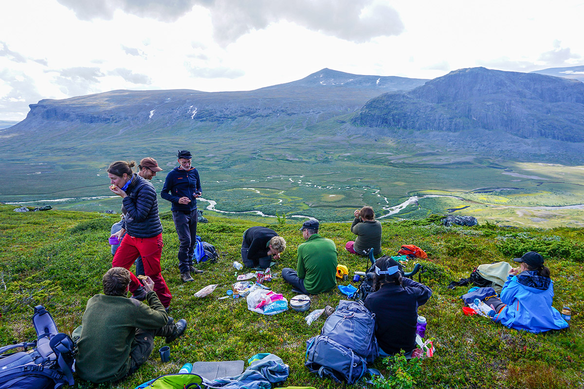 Efterr&auml;tten v&auml;xer p&aring; en arml&auml;ngds avst&aring;nd under lunchpausen p&aring; v&auml;g upp f&ouml;r Lulep Gierkav. Magnus Thelaus f&ouml;rklarar samtidigt hur ny forskning visar att inlandsisen i U-dalen nedanf&ouml;r dragit sig &aring;t sydost (v&auml;nster i bild) och inte &aring;t nordv&auml;st (h&ouml;ger i bild). Foto: Amanda Fagerlund