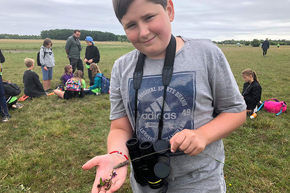 Jacob Haraldsson visar några blommor han tror sig ha identifierat till dagens första tävlingsmoment.