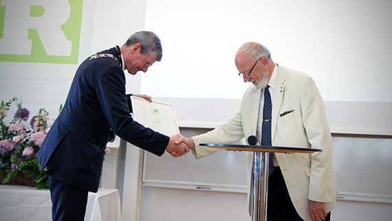 Rektor H&aring;kan Pihl l&auml;mnar &ouml;ver hedersutm&auml;rkelsen Rector Emeritus Maximus till tidigare rektor Kaj Bj&ouml;rk.