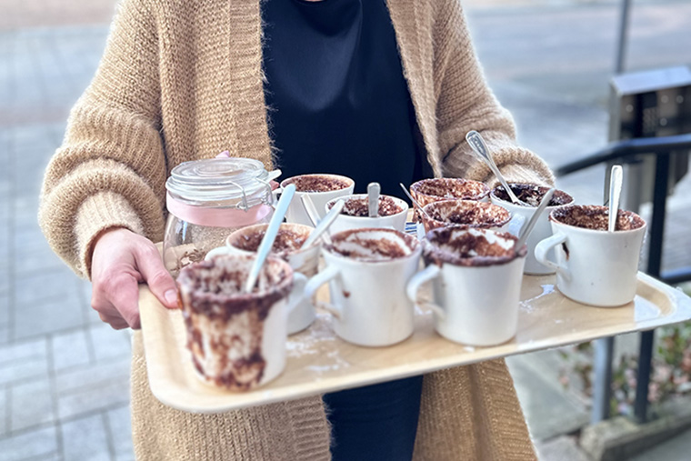 En bricka med muggar med bakad chokladkaka i.