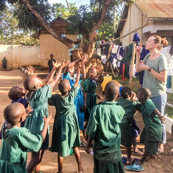 F&ouml;rskoll&auml;rarstudenten Anna Hellman bl&aring;ser s&aring;pbubblor tillsammans med barnen p&aring; Ssenyange Education Centre.