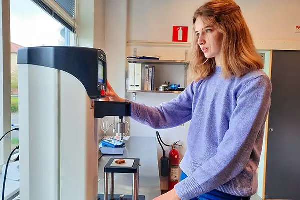 Franska g&auml;ststudenten Lucie Borodacz analyserar texturen i en kaka med hj&auml;lp av en penetrometer, ett slags h&aring;rdhetsm&auml;tare.
