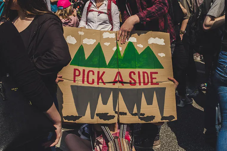 Demonstranter med plakat med texten Pick a side!