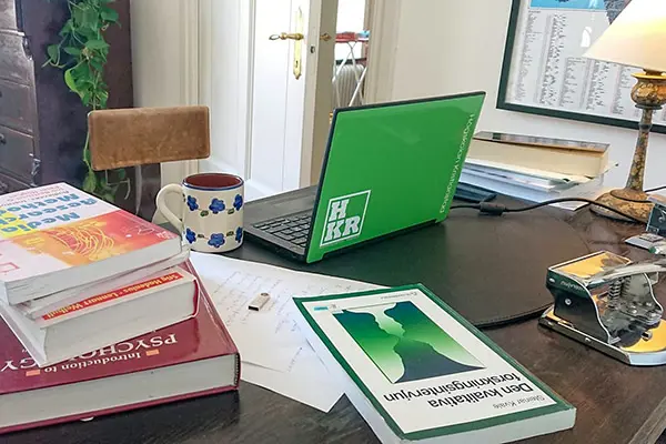 Distansstudier med kurslitteratur och laptop p&aring; skrivbord.