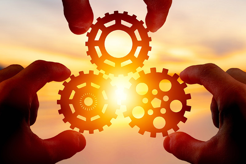 Solnedg&aring;ng mellan tre kugghjul.