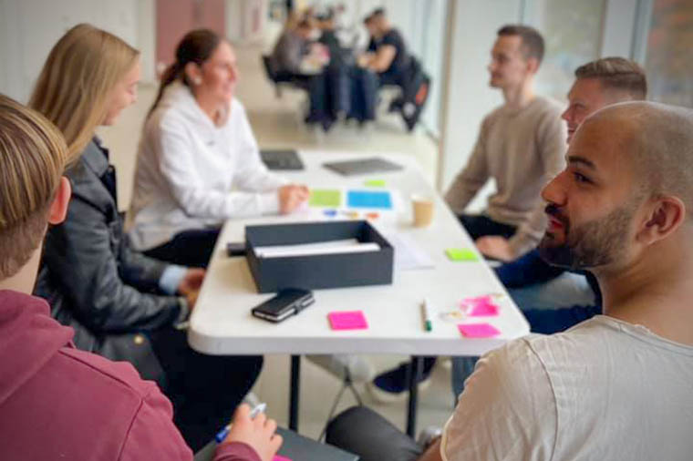 Studenter innoverar runt ett bord.