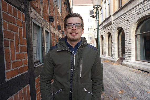 André står på en gata och tittar in i kameran