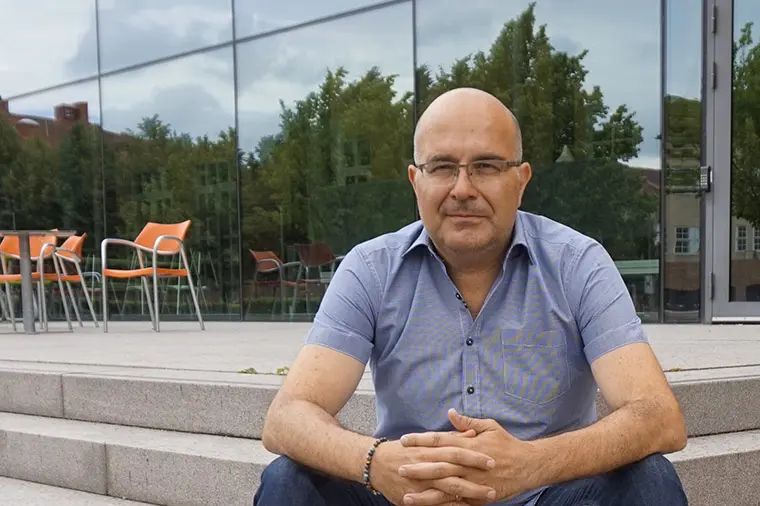 Professor Giuseppe Grossi sitter p&aring; trappan till glashuset, H&ouml;gskolan Kristianstad.