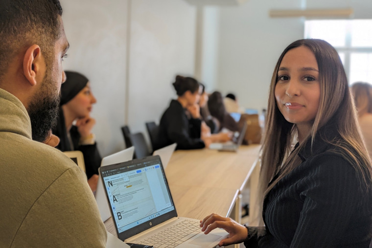 Studenter sitter runt ett bord i workshop