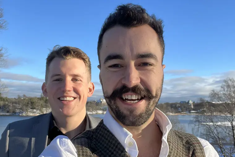John och Karsten ler in i kameran en fin vinterdag med blå himmel och en stilla sjö bakom sig