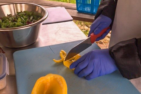 Deltagare skivar gul paprika p&aring; Habo G&aring;rd.