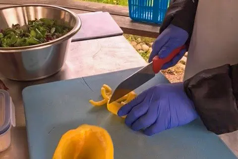 Deltagare skivar gul paprika p&aring; Habo G&aring;rd.
