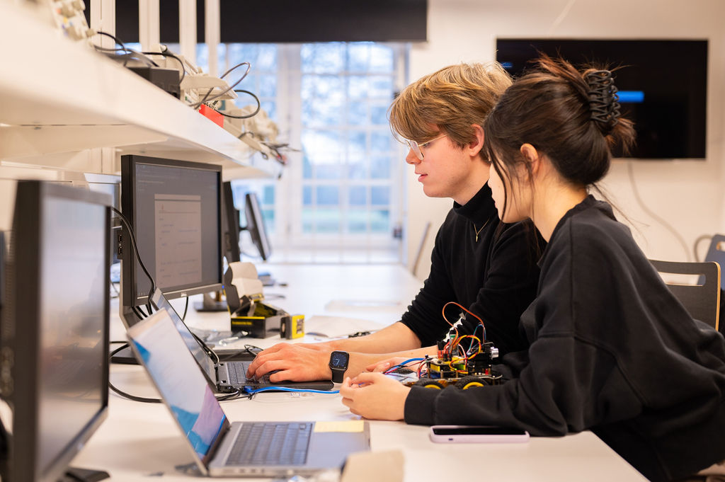 Två studenter framför en dator