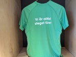 Grön sporttröja med trycket "Vi ligger alltid steget före" på ryggen