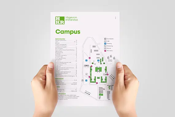 Två händer håller en karta över campus