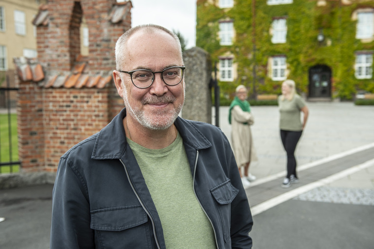 Tre medarbetare utomhus på högskolans campus.