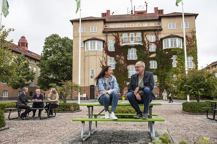 Medarbetare utomhus på högskolas campus.