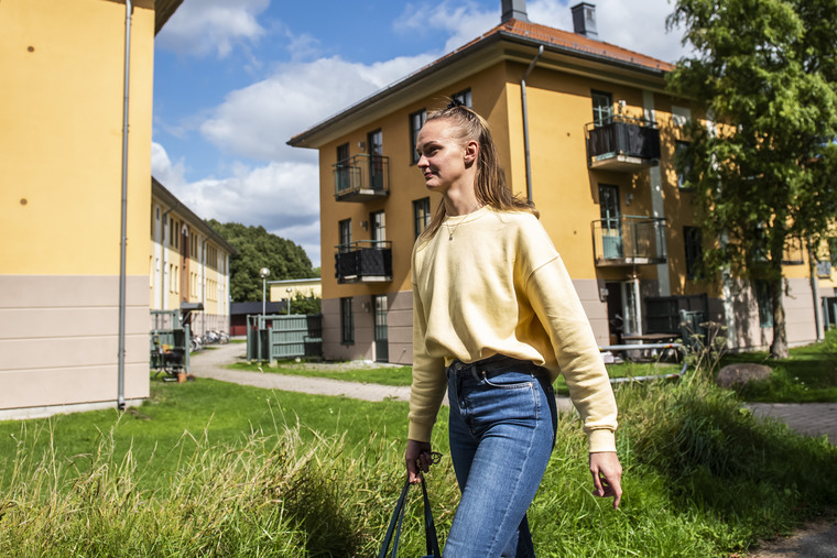 En student går utanför studentbostäderna.