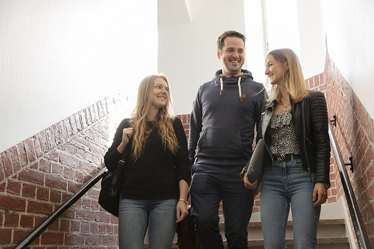 Tre studenter går ner för trappa