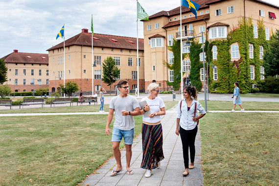 Tre studenter går på högskolans campus.