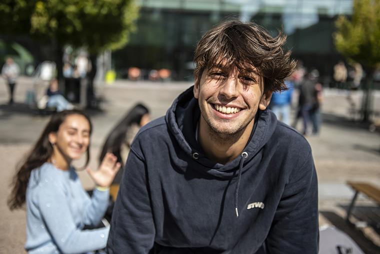 Leende student utomhus.