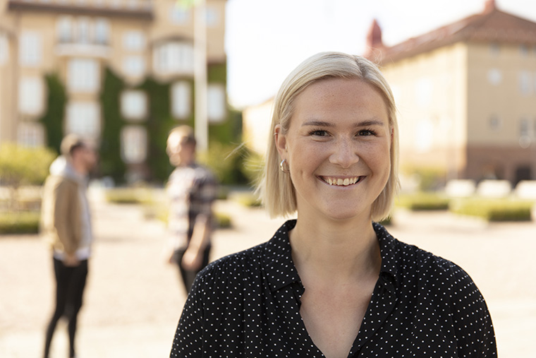 Tjej på campus, tittar in i kameran