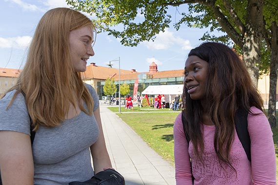 Två studenter samtalar ute på campus