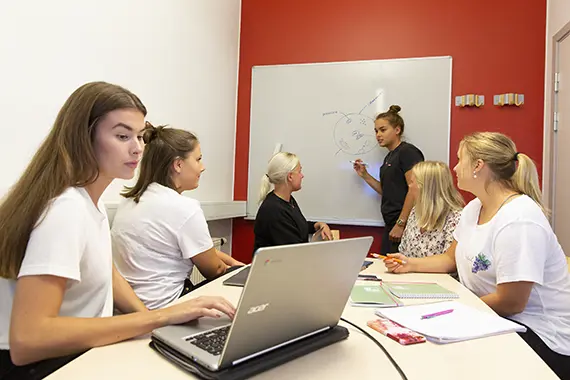 Studenter som grupparbetar, vid en whiteboard