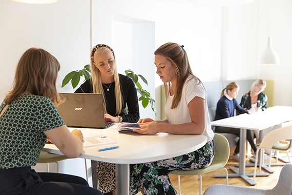 Tre tjejer sitter vid ett bord