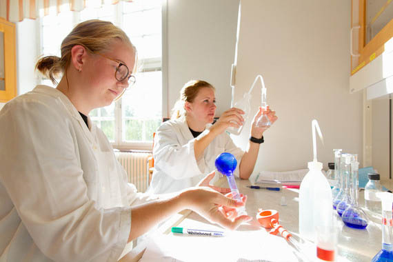 Tv&aring; vitkl&auml;dda studenter i laboratoriemilj&ouml;.
