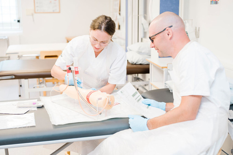 Sjuksk&ouml;terskestudent och l&auml;rare i metodrummet.