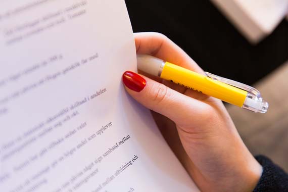 Hand som håller i penna och papper