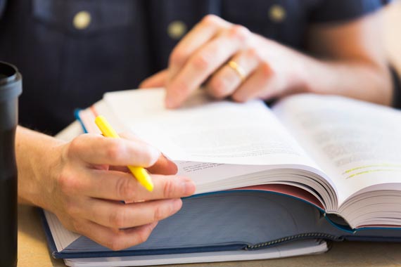 Händer bläddrar i bok