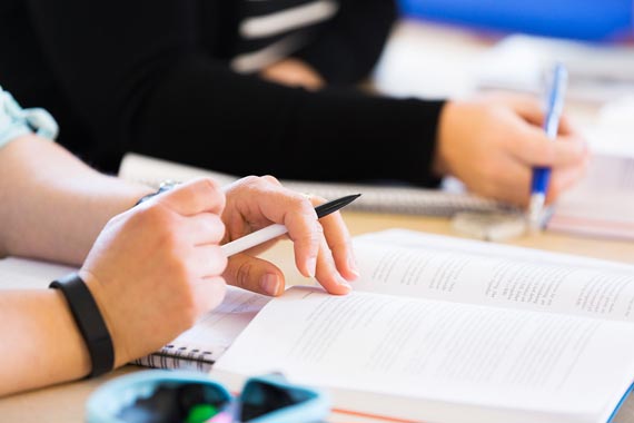 Närbild på händer som håller på bok